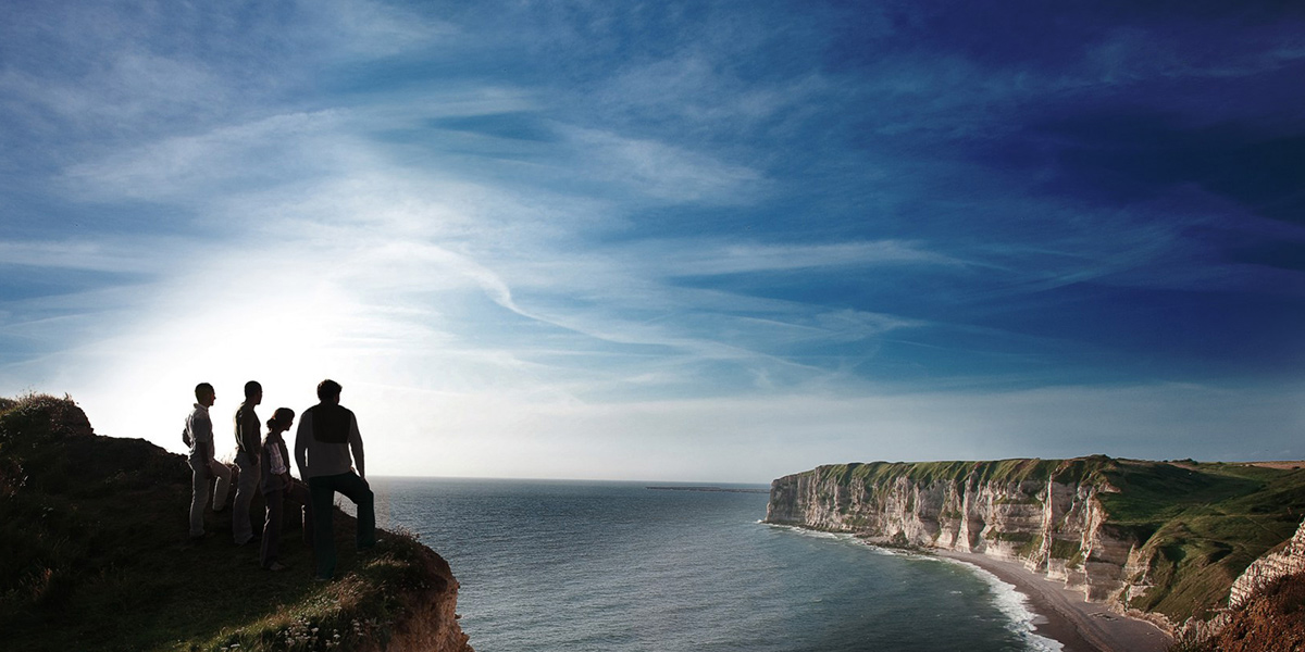 personnages regardant les falaises de normandie en bord de mer